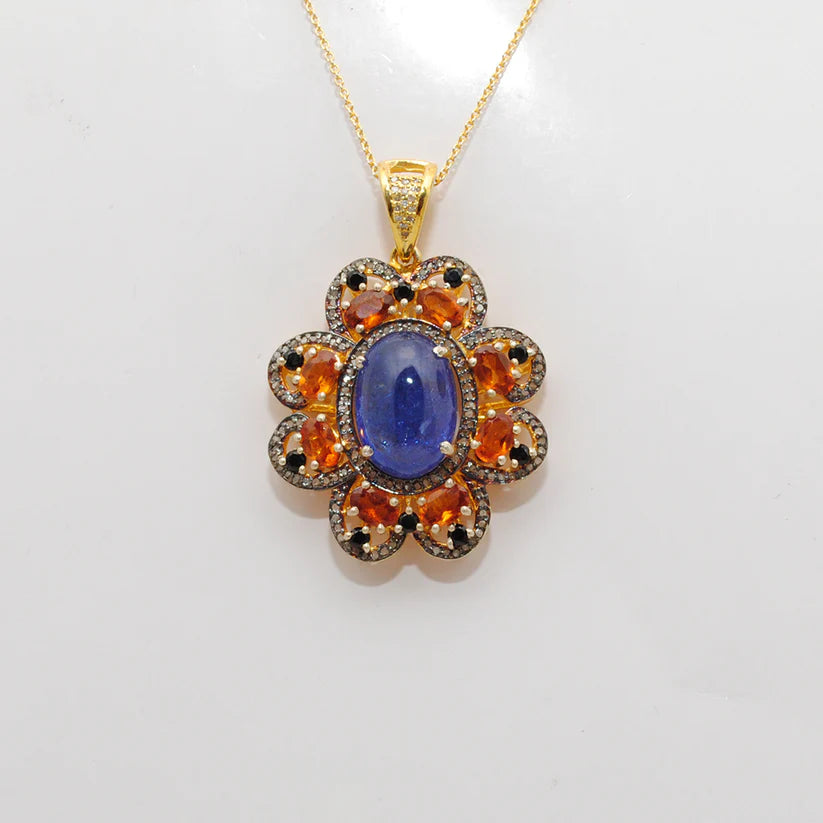 Gold-plated sterling silver pendant featuring tanzanite, sapphire, and black spinel gemstones accented with shimmering pavé-set diamonds in a luxurious design