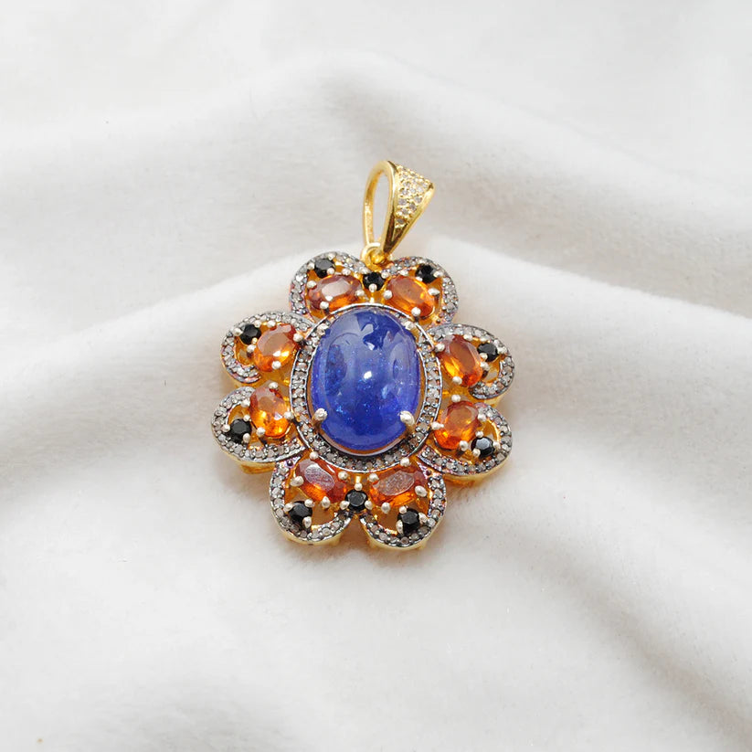 Gold-plated sterling silver pendant featuring tanzanite, sapphire, and black spinel gemstones accented with shimmering pavé-set diamonds in a luxurious design