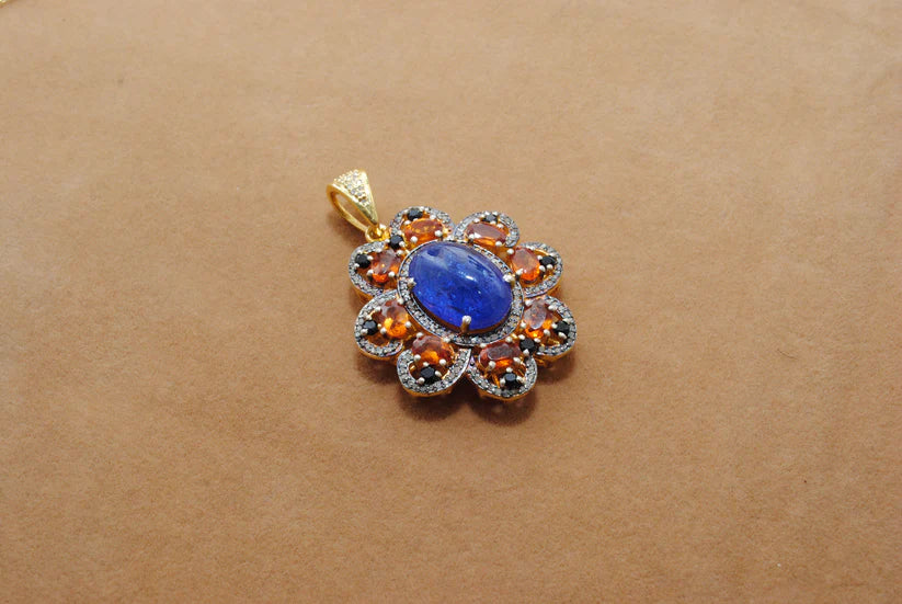 Gold-plated sterling silver pendant featuring tanzanite, sapphire, and black spinel gemstones accented with shimmering pavé-set diamonds in a luxurious design
