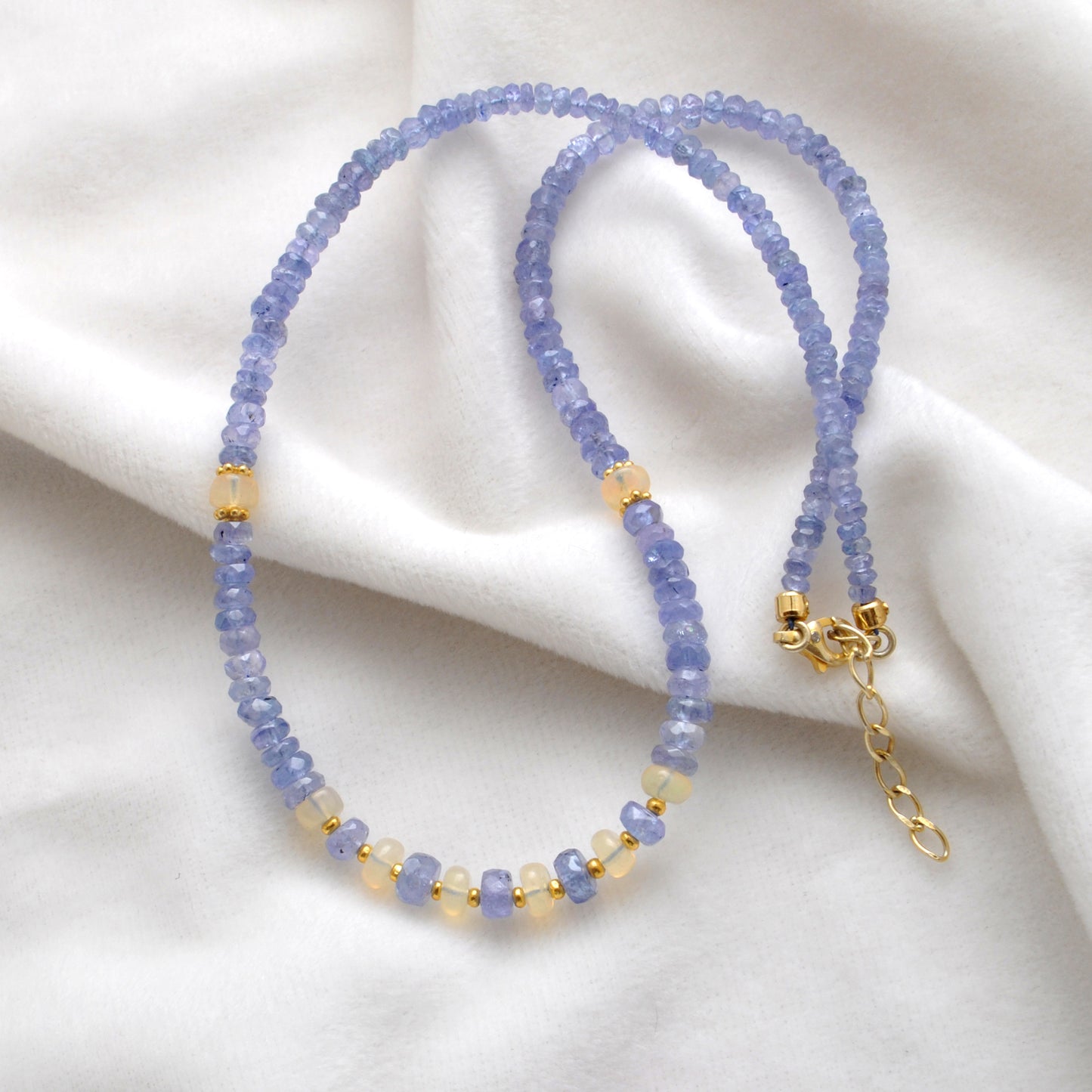 "Faceted tanzanite and Ethiopian opal beaded necklace with gold-plated finish, iridescent gemstone jewelry."